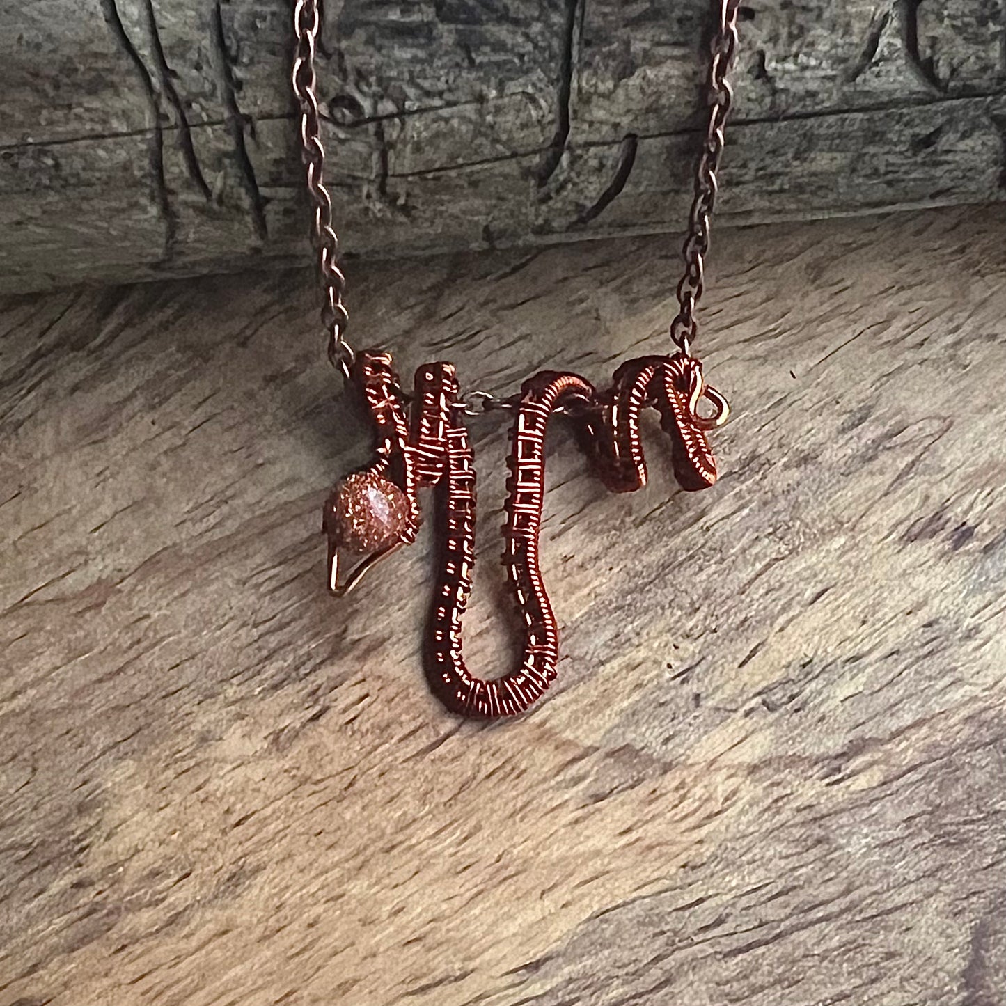 Necklace with copper snake and gold stone