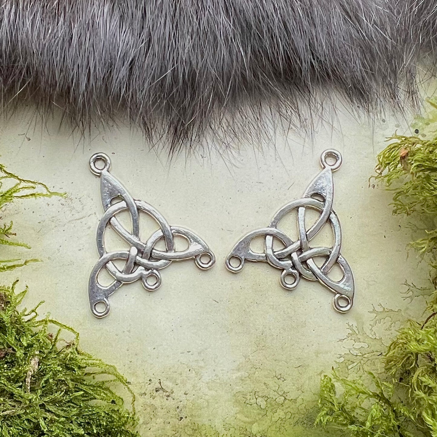 Vikingatida dräktsmycke. Pärlspridare för tre pärlrader med Triquetra