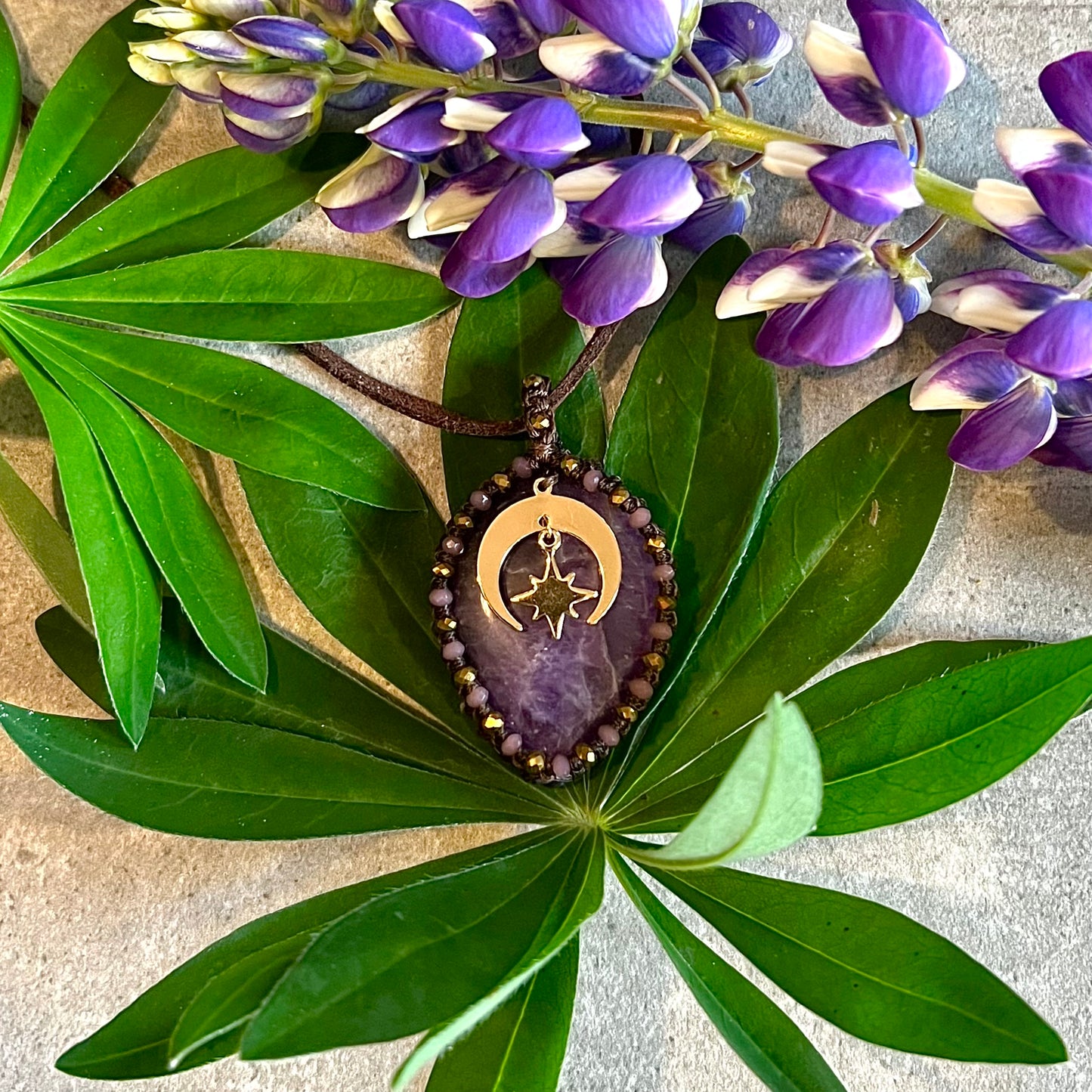 Necklace with bound amethyst and gold-plated charms