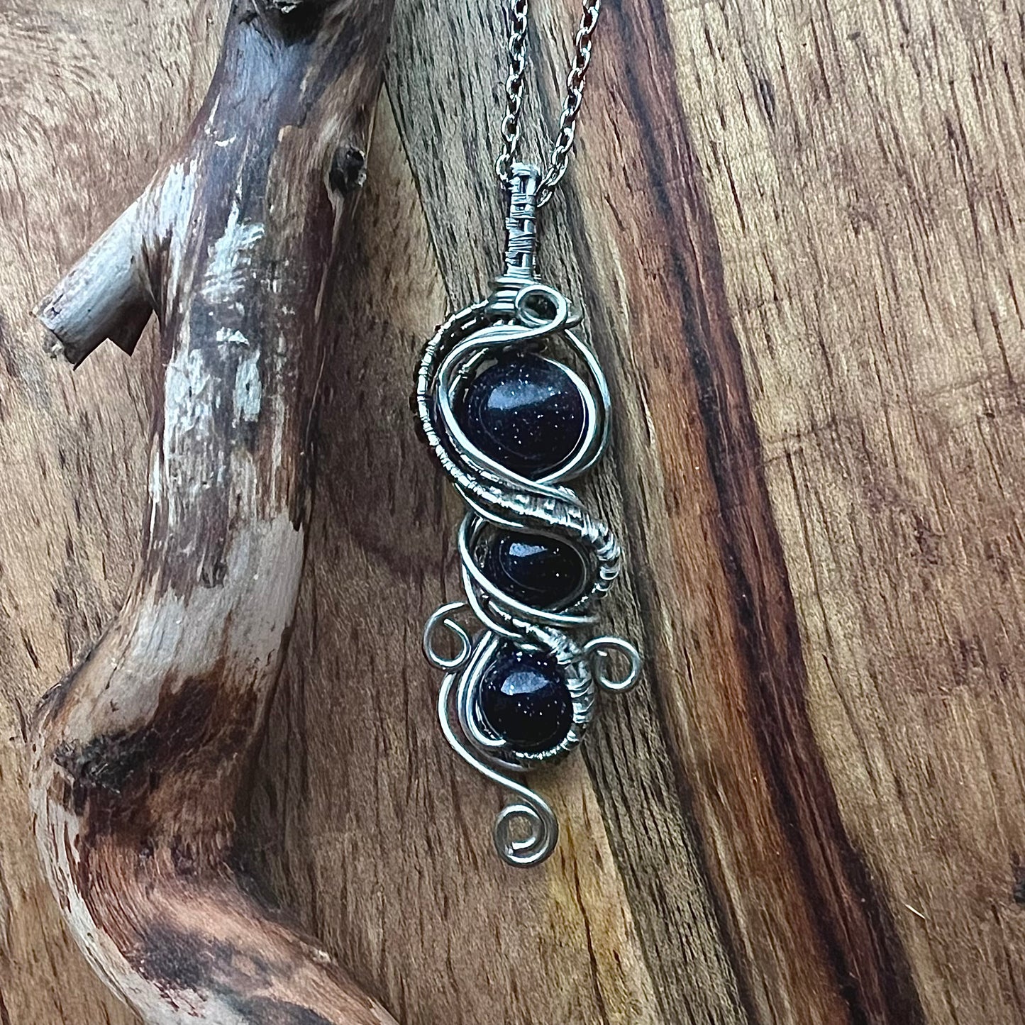 Necklace with blue gold stone and silver-colored copper wire