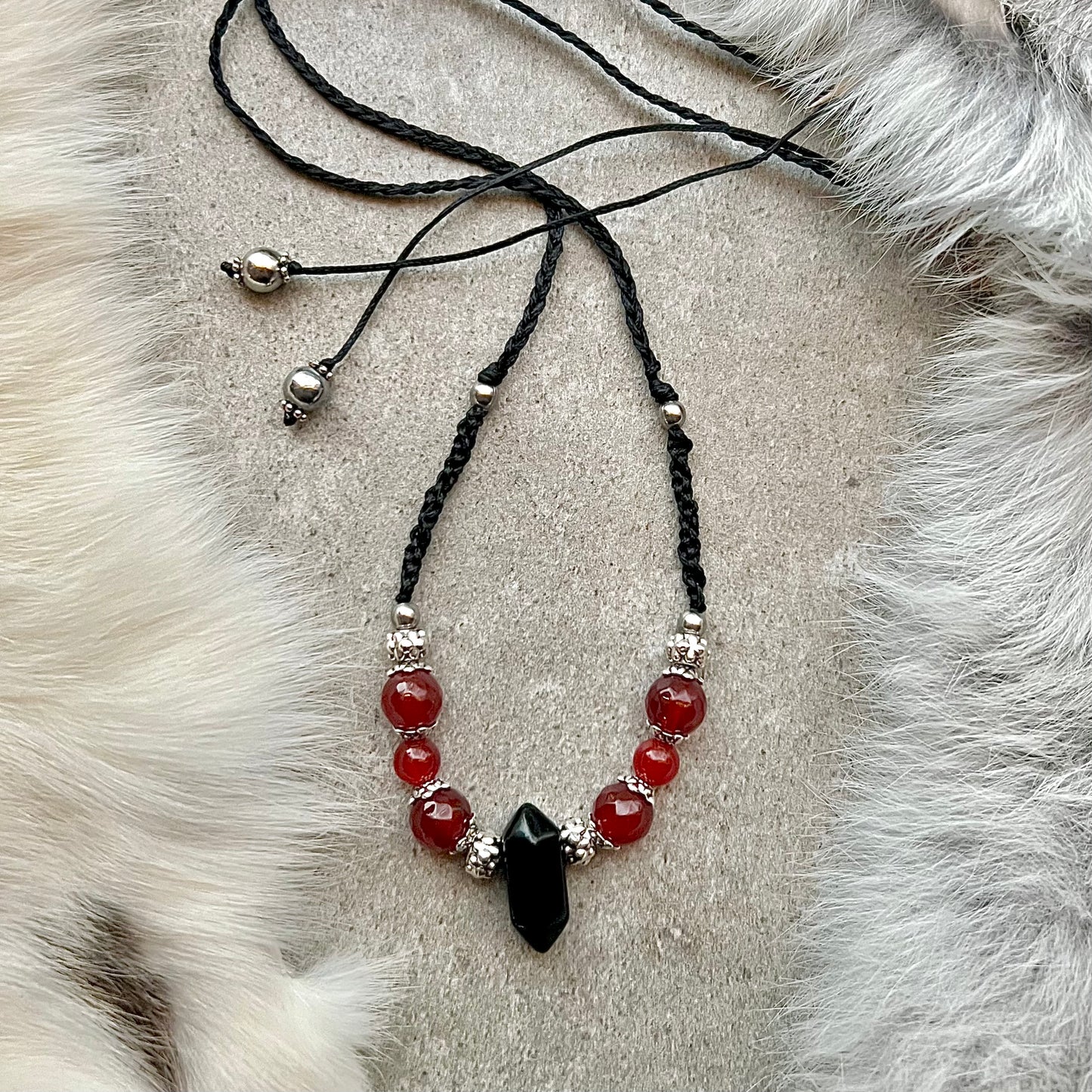 Hand-knotted necklace with faceted carnelian and obsidian lace