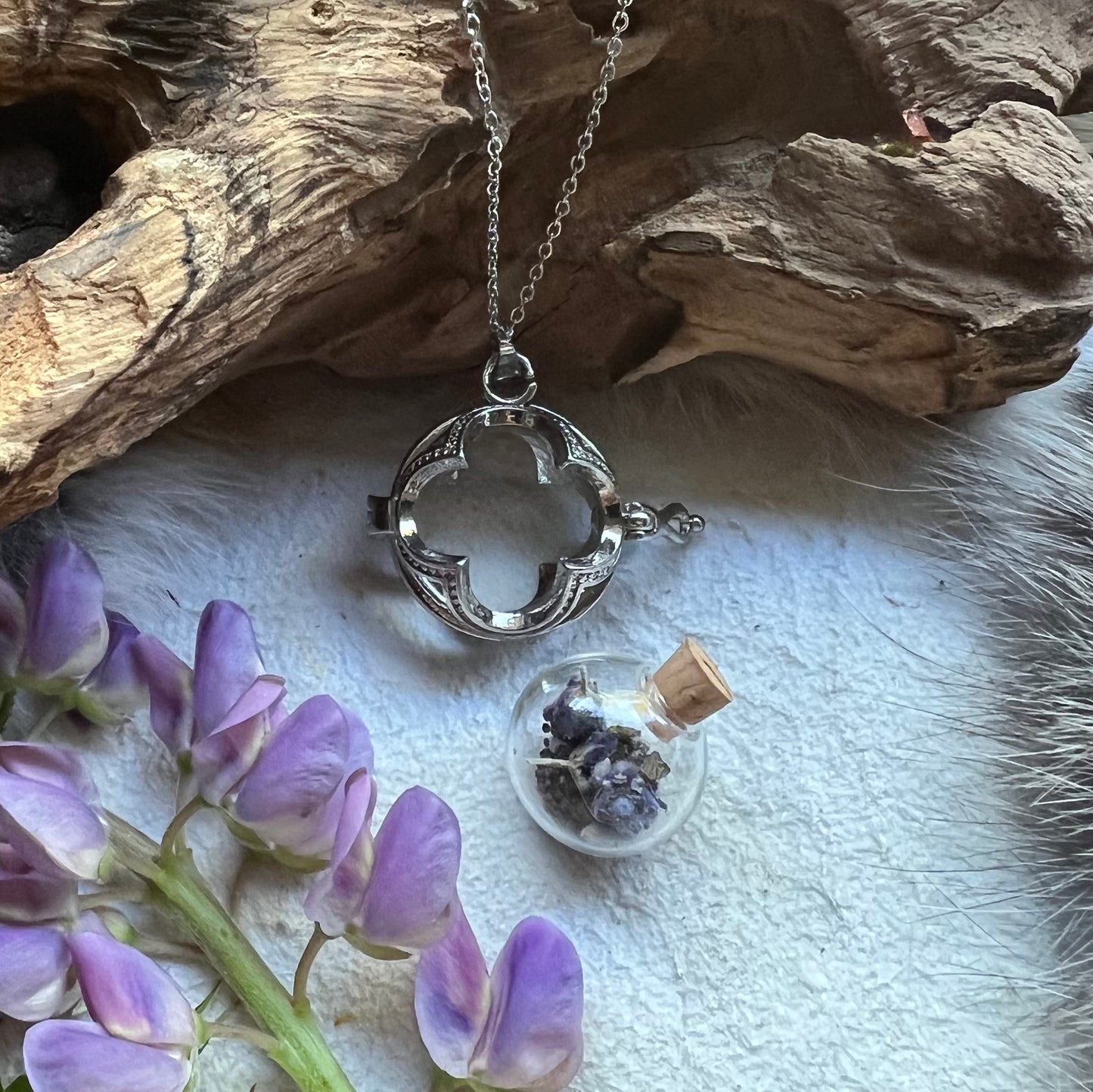 Silver colored necklace with glass vessel and lavender