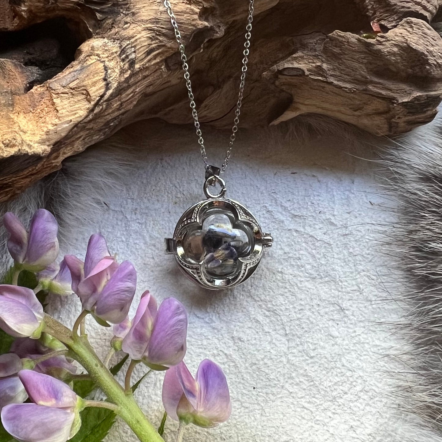 Silver colored necklace with glass vessel and lavender