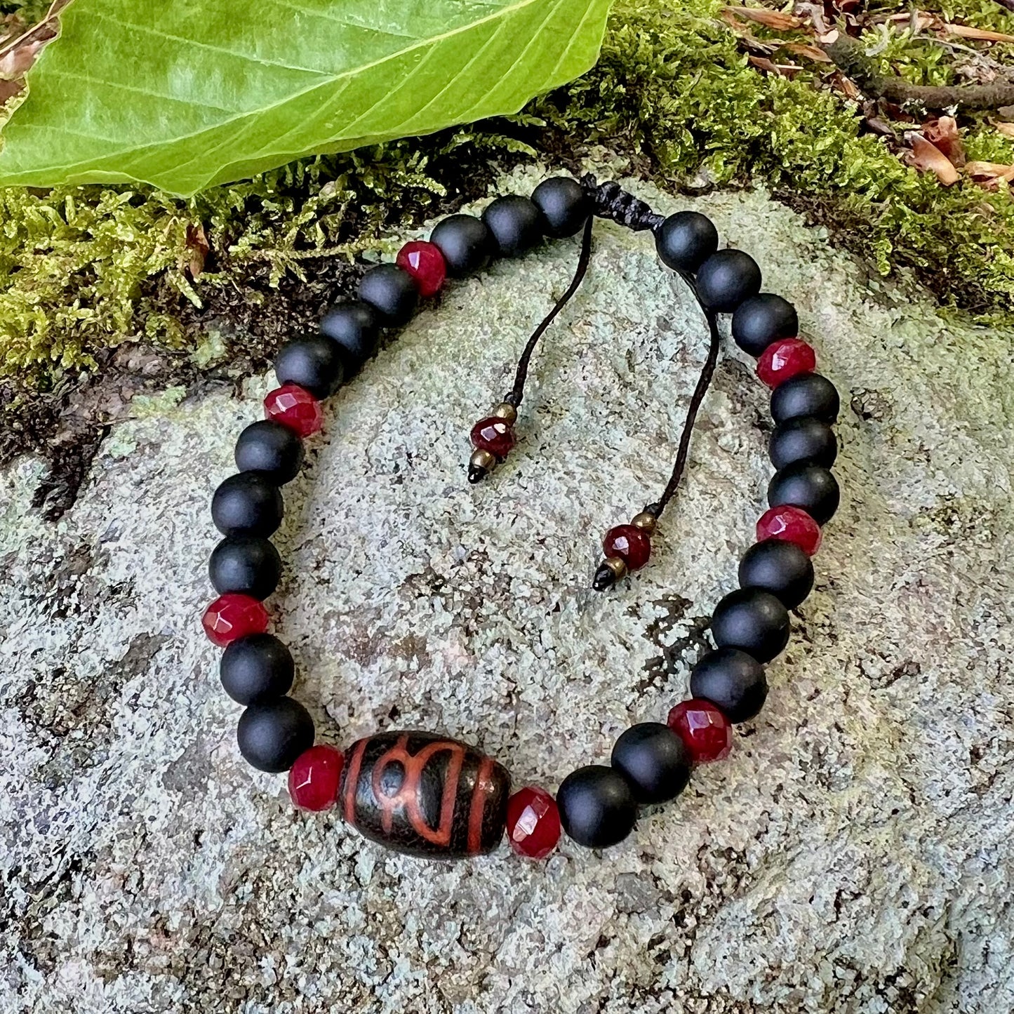 Handknutet armband med Dzi-pärla, fasetterad jade och svart glas