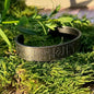 Armring med runor i svart, rostfritt stål