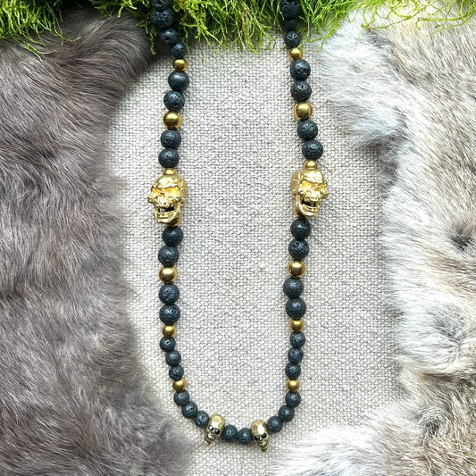 Necklace of black frosted glass and skulls of brass