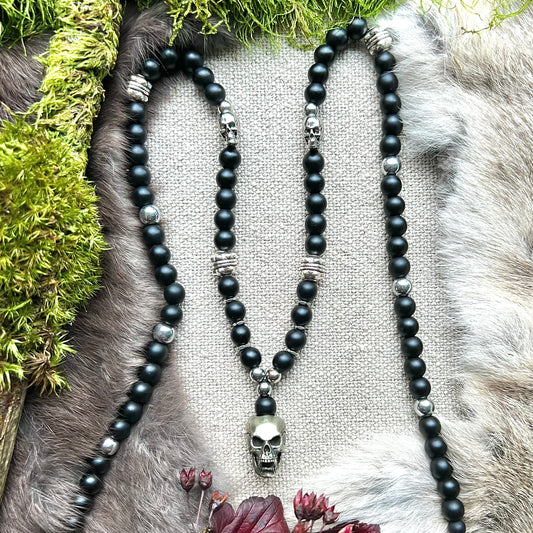 Necklace of black frosted glass with steel and brass skulls